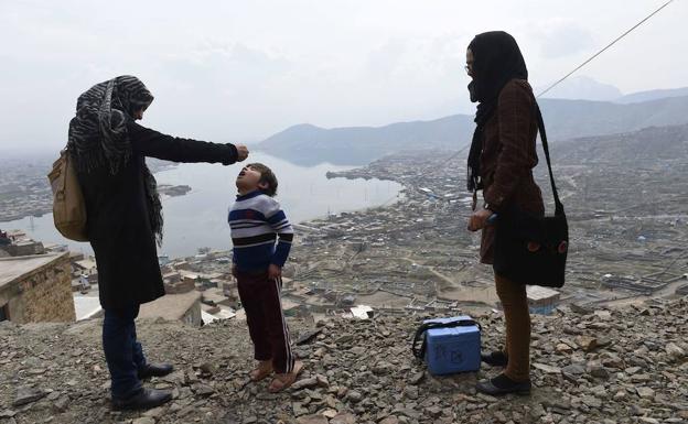 Un médico afgano sumistra la vacuna antipoliomielítica a un niño en Kabul. /Shah Marai (Afp)
