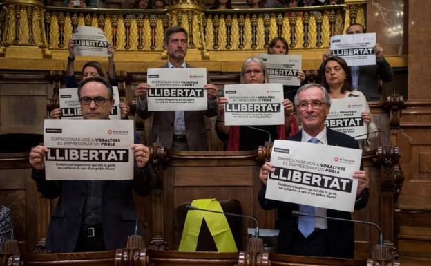 Carteles y un lazo amarillo en el pleno.