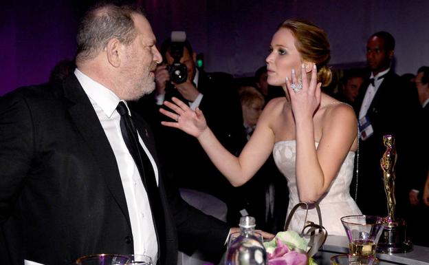 Jennifer Lawrence (d) habla con Harvey Weinstein en una fiesta. /KEVORK DJANSEZIAN (AFP)