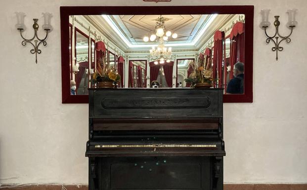 Piano con el Salón de los Espejos reflejado.