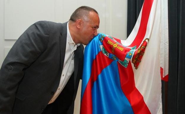 El presidente del Consejo Comarcal, Gerardo Álvarez Courel, besa la bandera de El Bierzo durante su toma de posesión./César Sánchez