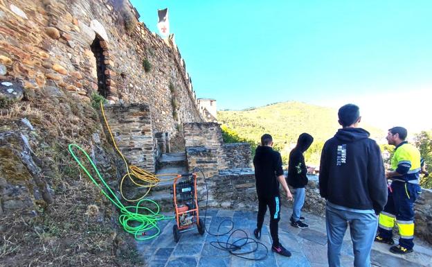 Los jóvenes continúan con la limpieza de la pintadas del castillo.