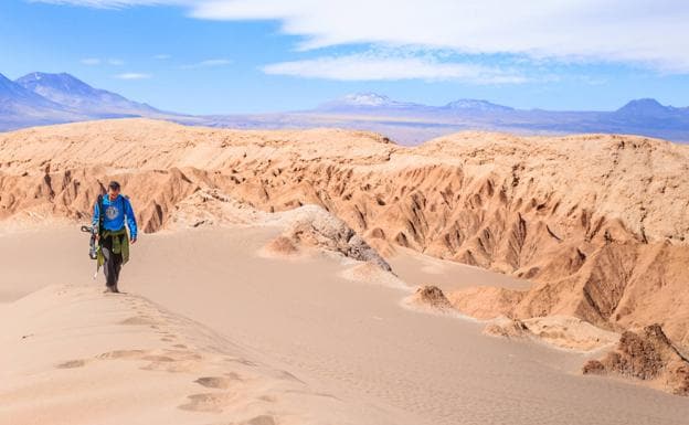 Un hombre pasea por el desierto de Atacama antes de practicar 'sandboard'. /Turismo de Chile.