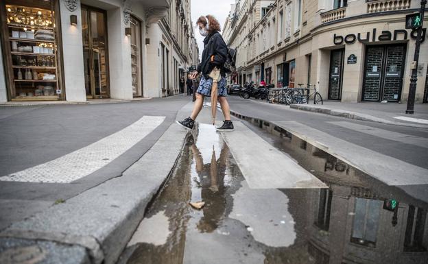 Una mujer con mascarilla pasea por París
