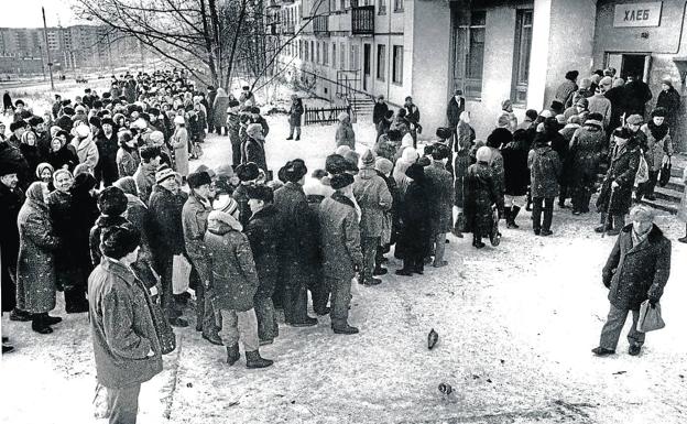 La cola del pan. Numerosas personas esperan para comprar el pan en Cheliábinsk, en el año 1985. Muebles y enseres en la escalera. /imágenes del libro 'el siglo soviético'