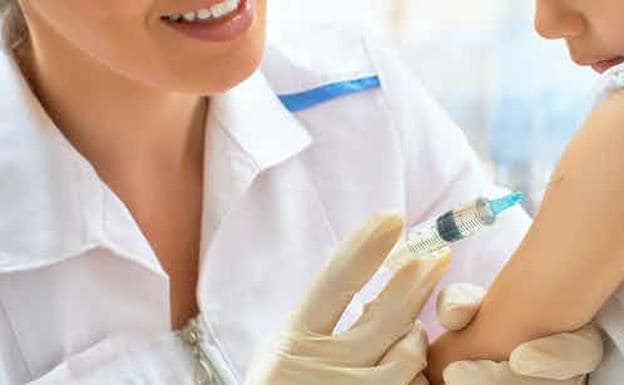 Una enfermera poniendo una vacuna a una niña./R.C.